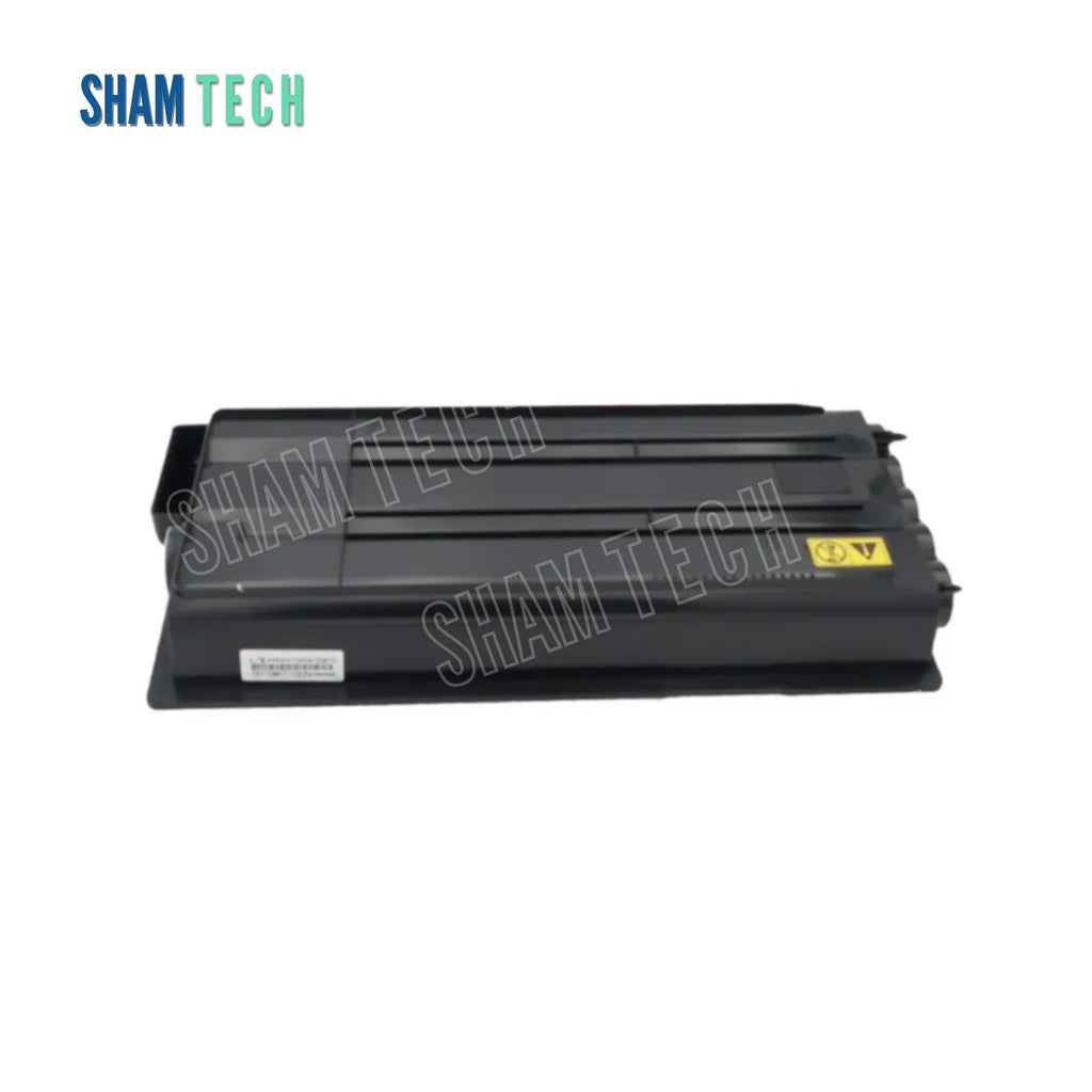 A black Kyocera laser toner cartridge is displayed horizontally without it's box against a plain white background. The rectangular plastic cartridge features structural ridges across its top surface, a small white tracking label on the lower-left side, and a yellow warning symbol on the right. The "SHAM TECH" logo appears in the top-left corner, and a large translucent "SHAM TECH" watermark is overlaid diagonally across the center of the image.